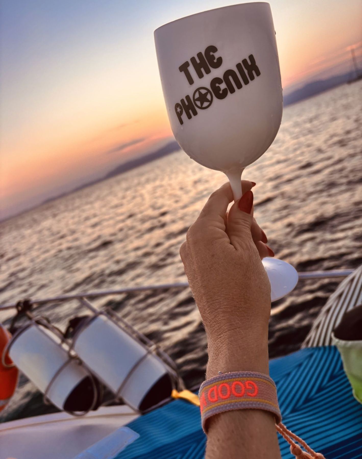 Ein Glas in der Hand vor dem Sonnenuntergang